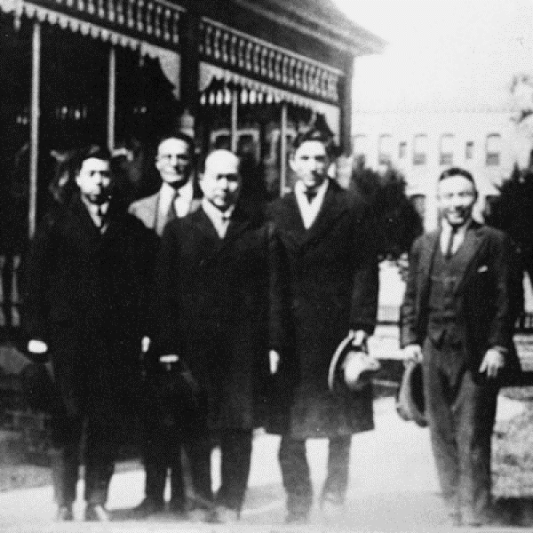 Group photo of men standing in front of a building