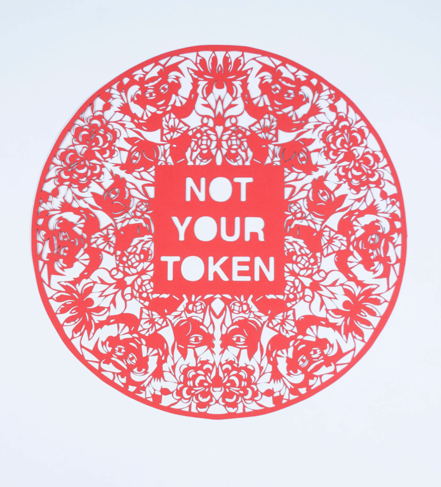 Red paper cutting that reads "NOT YOUR TOKEN"