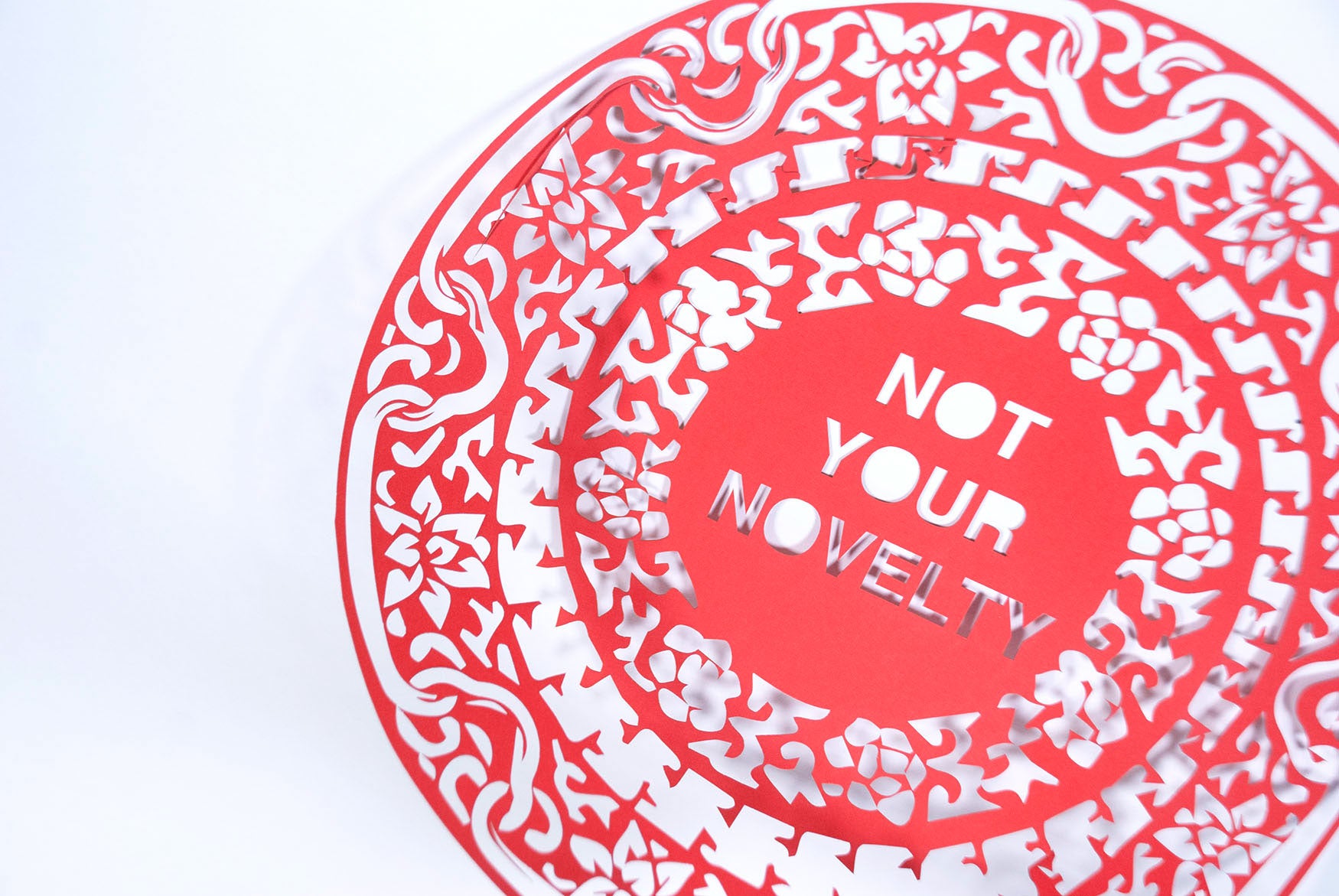 Red paper cutting that reads "NOT YOUR NOVELTY"